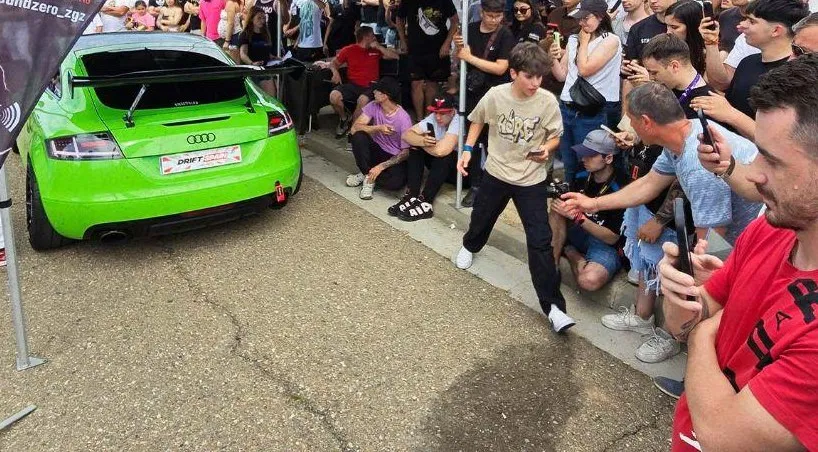 Público rodeando un Audi TT verde modificado en Figueruelas